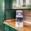Aqualine waterfilter op houten aanrecht in keuken met groene keukenkasten